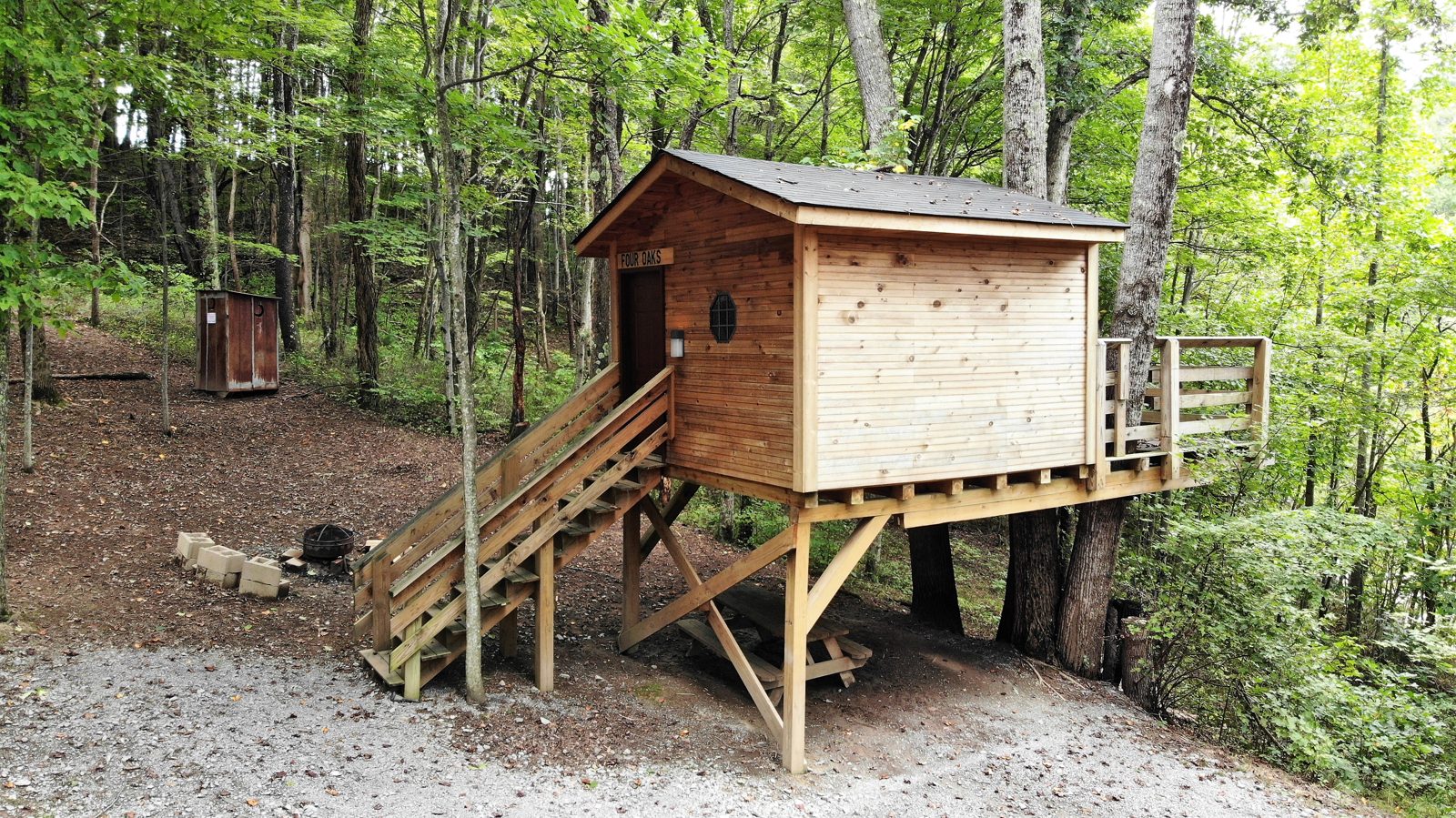 Four Oaks rustic treehouse elevated on posts in the Appalachian forest