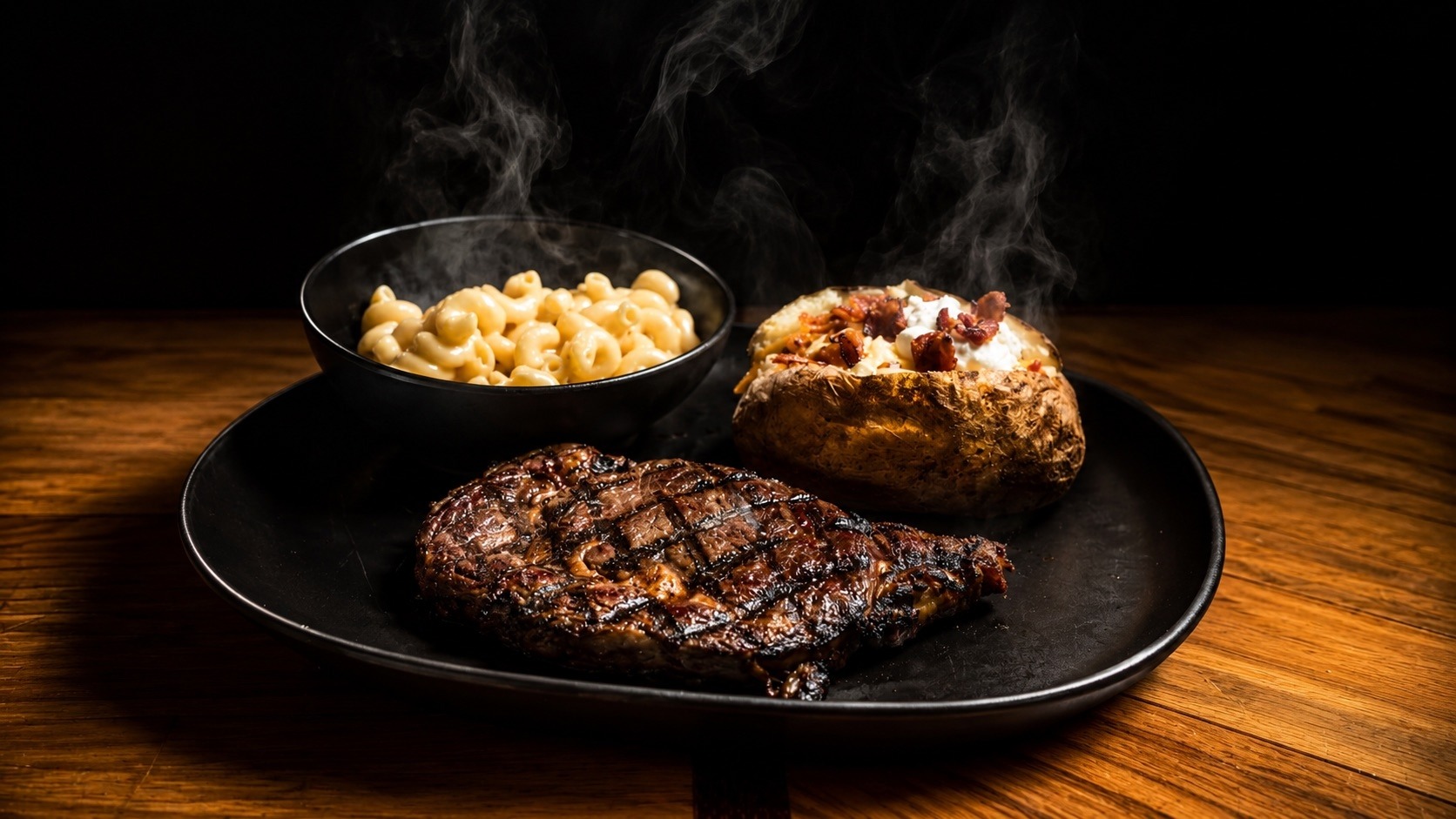 Ribeye steak with mac and cheese and loaded baked potato